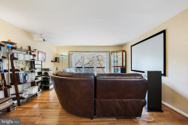 home theater room with baseboards and light wood-style floors