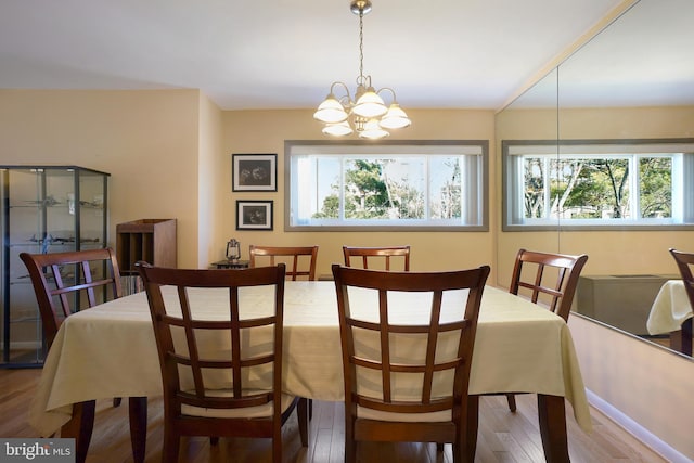 dining space with a notable chandelier, wood finished floors, and a wealth of natural light