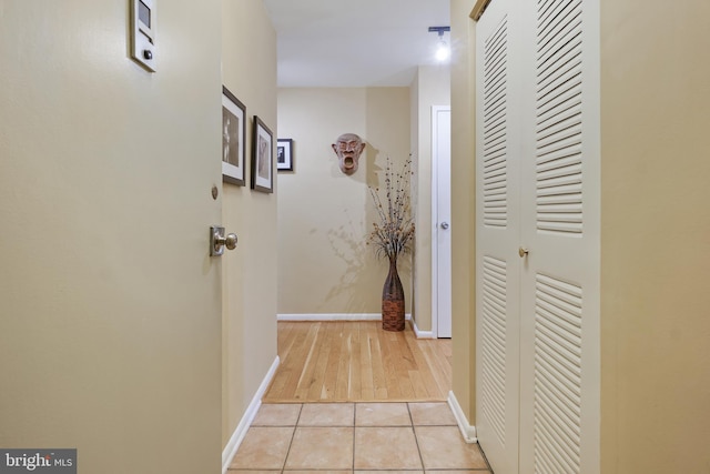 hallway with light tile patterned floors and baseboards