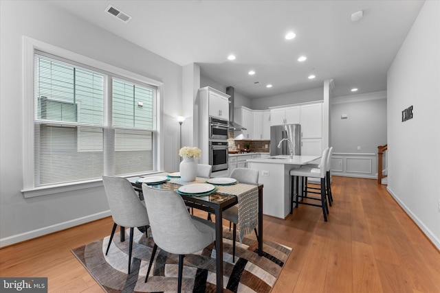 dining room featuring light wood-style flooring, visible vents, baseboards, and recessed lighting