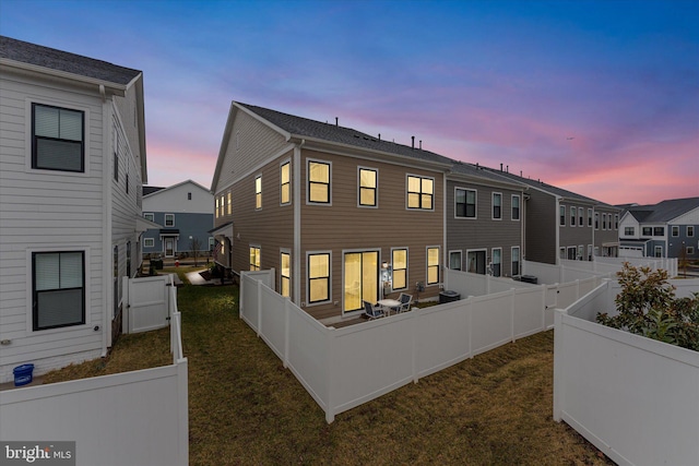 back of property featuring a fenced backyard and a lawn