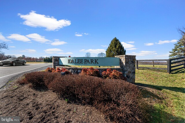 community / neighborhood sign featuring fence