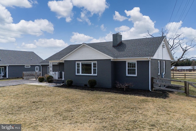 view of front of house with brick siding, a front yard, and fence