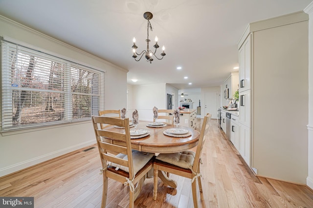 dining space with a notable chandelier, baseboards, visible vents, and light wood finished floors