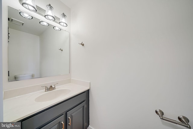 bathroom featuring vanity, toilet, and visible vents