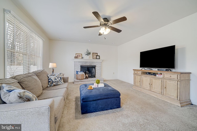 carpeted living area with a ceiling fan and a fireplace