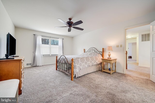 carpeted bedroom with baseboards, visible vents, and ceiling fan