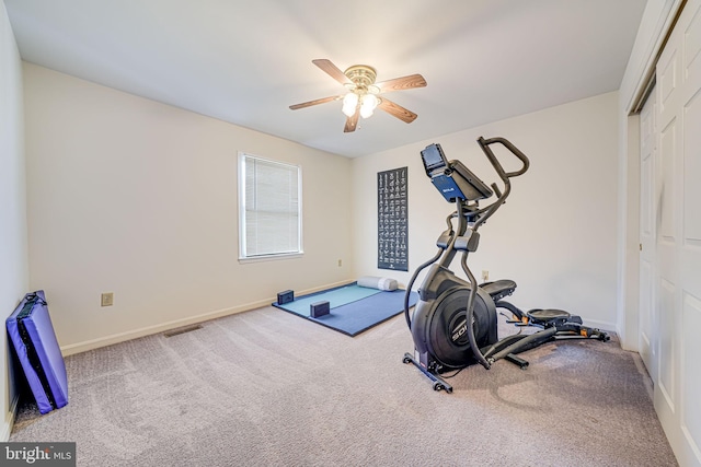 exercise area featuring a ceiling fan, baseboards, and carpet floors