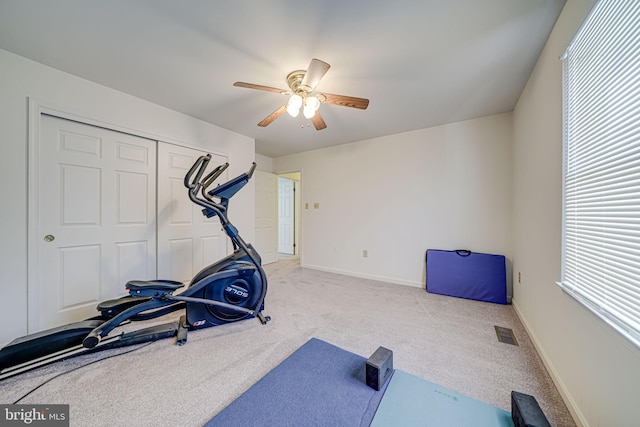 exercise room with carpet flooring, visible vents, a ceiling fan, and baseboards