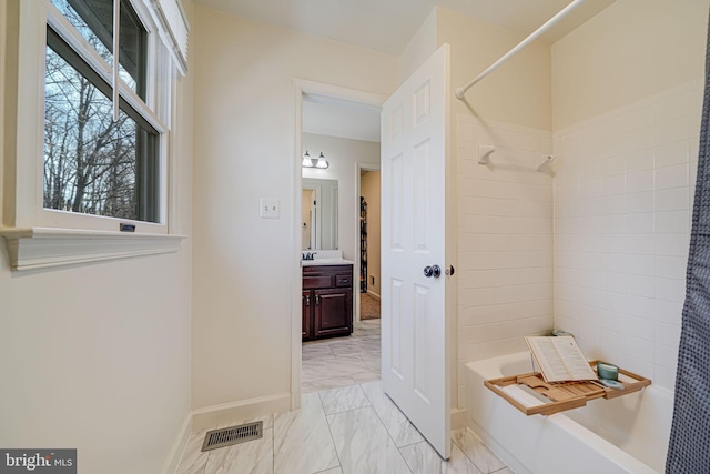 bathroom with vanity, washtub / shower combination, visible vents, baseboards, and marble finish floor