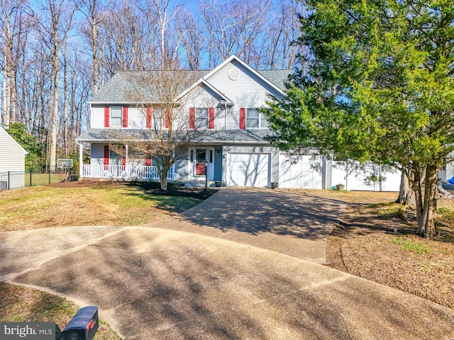 view of front of house featuring a front lawn, driveway, a porch, fence, and a garage