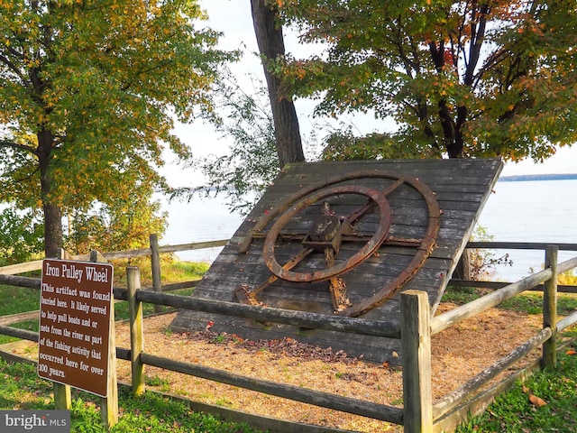 community sign featuring fence and a water view