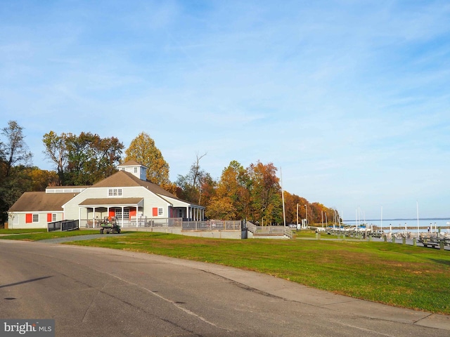 view of front of house with a front lawn and a water view