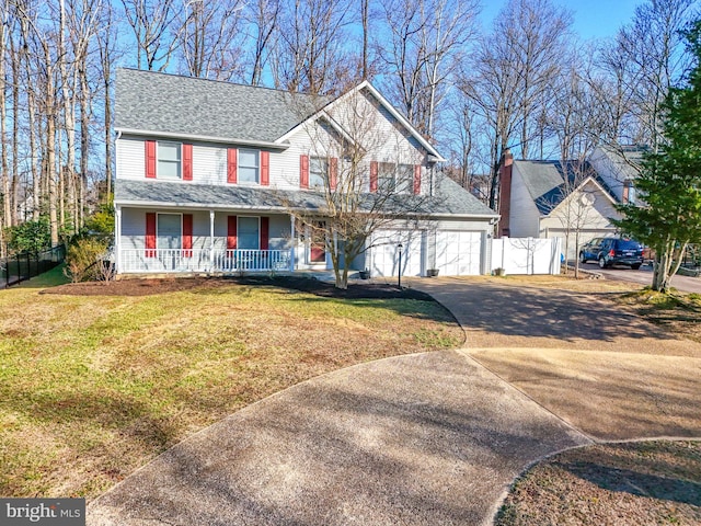 view of front of property featuring driveway, fence, covered porch, an attached garage, and a front yard