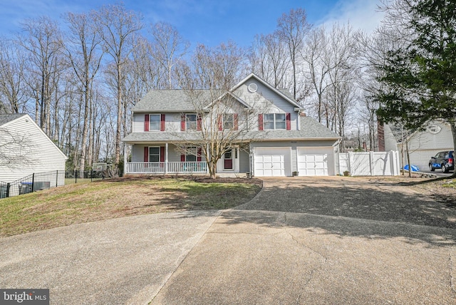 view of front facade with a gate, fence, driveway, a porch, and a front lawn