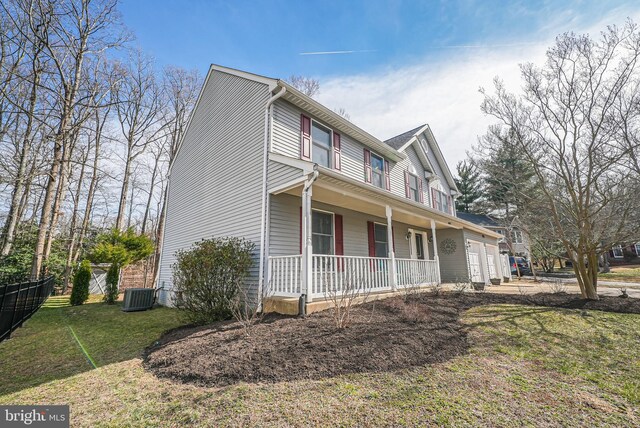 view of front of home featuring central air condition unit, a porch, a front yard, and fence