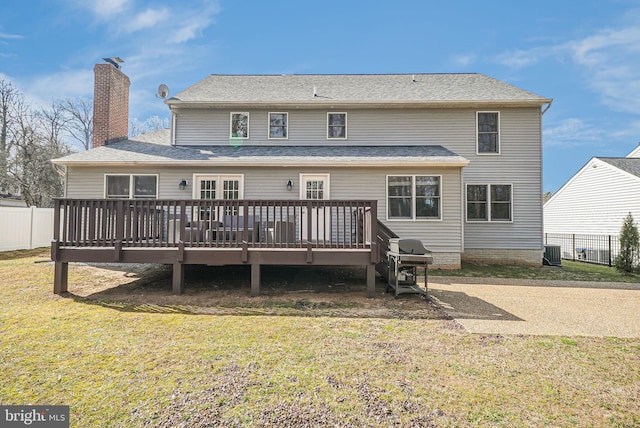 back of property featuring fence, a yard, a wooden deck, central AC unit, and a chimney