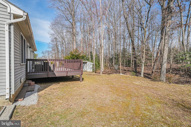 view of yard with a storage shed, an outbuilding, and a wooden deck