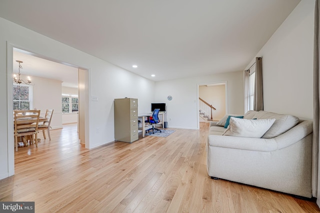 living area with stairway, baseboards, an inviting chandelier, light wood-style flooring, and recessed lighting