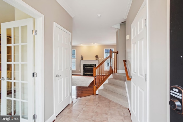 interior space featuring stairs, crown molding, baseboards, and light tile patterned floors