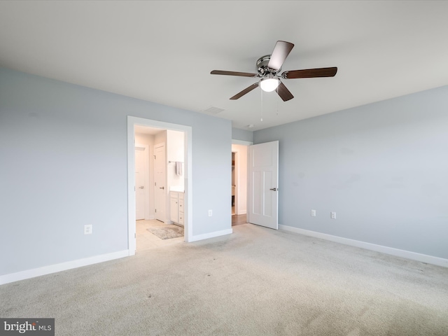 unfurnished bedroom featuring visible vents, baseboards, ceiling fan, ensuite bath, and light colored carpet