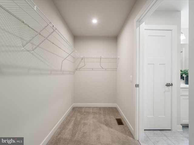 walk in closet featuring light carpet and visible vents