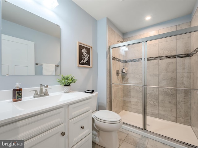 full bathroom featuring a shower stall, vanity, tile patterned flooring, and toilet