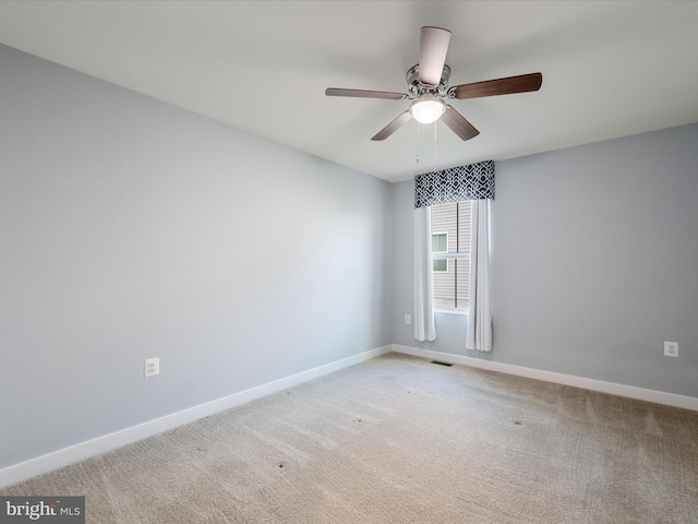 unfurnished room with visible vents, baseboards, a ceiling fan, and light colored carpet