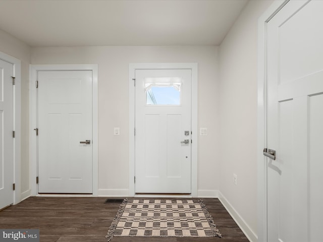 foyer featuring baseboards and dark wood finished floors