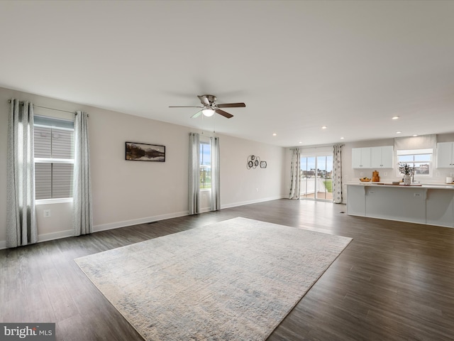 unfurnished living room featuring dark wood-style floors, baseboards, a ceiling fan, and recessed lighting