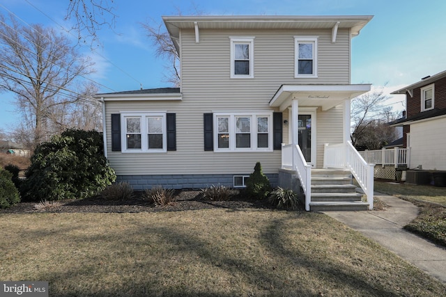 view of front of home with a front yard and central AC