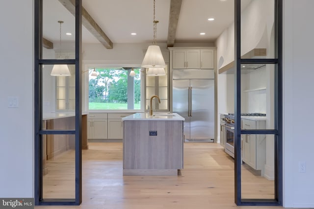 11 Sailfish Dr, Mechanicsburg, PA 17050 - kitchen featuring high end appliances, beamed ceiling, light wood-style flooring, an island with sink, and light countertops