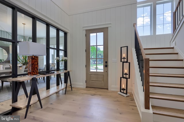 interior space featuring stairs, light wood-type flooring, and baseboards