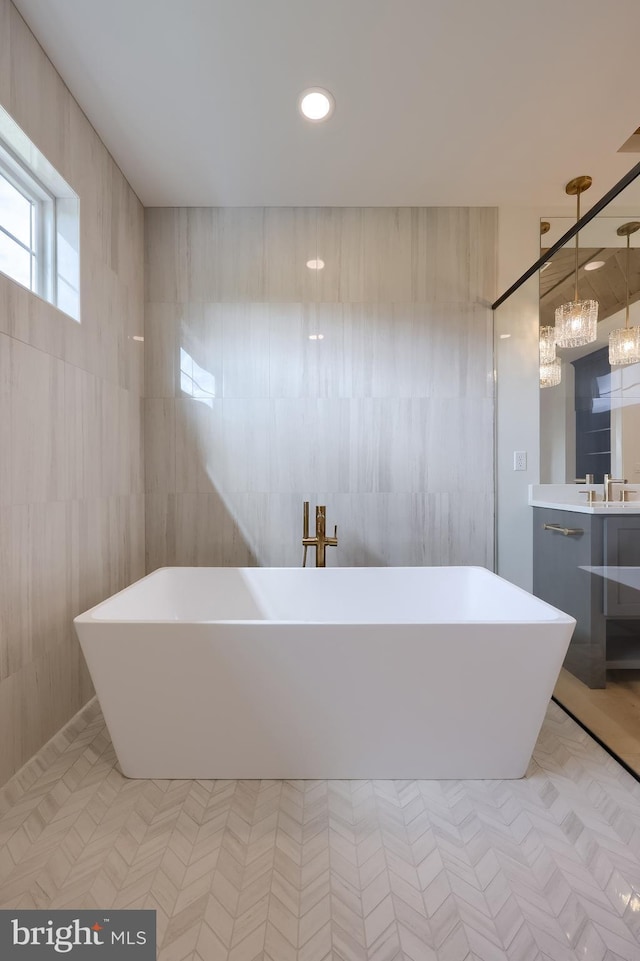 11 Sailfish Dr, Mechanicsburg, PA 17050 - full bathroom featuring vanity, a freestanding tub, tile walls, and a chandelier
