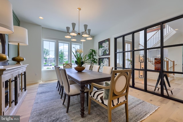 dining area with a chandelier, light wood-type flooring, baseboards, and recessed lighting