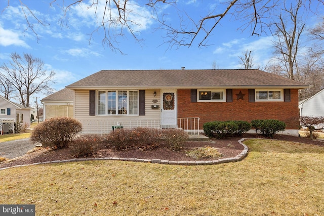 ranch-style home with brick siding, a front yard, and a shingled roof