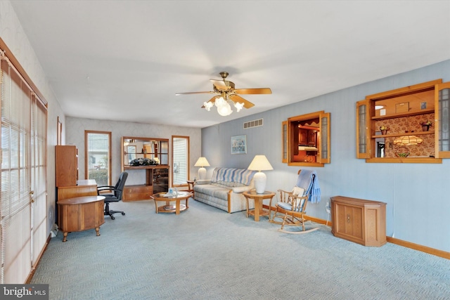 carpeted living area with baseboards, visible vents, and a ceiling fan