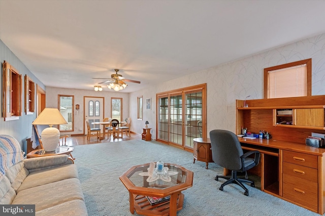 interior space with a ceiling fan and wallpapered walls