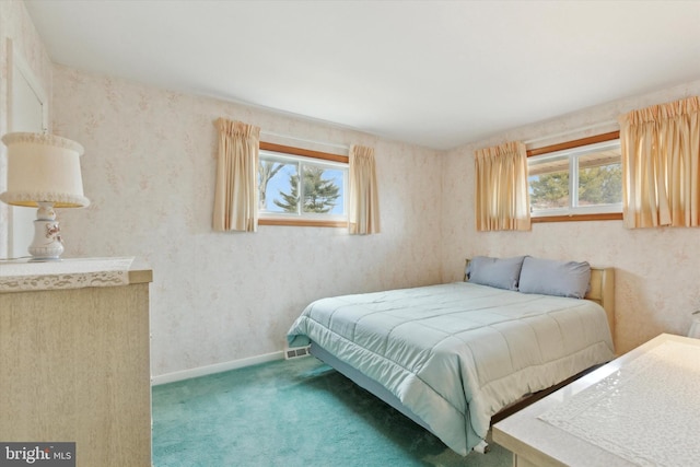 carpeted bedroom with wallpapered walls and baseboards