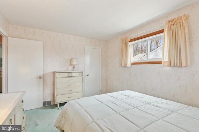 bedroom with light carpet and wallpapered walls