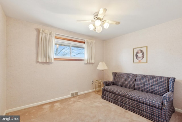 carpeted living room with baseboards, visible vents, and a ceiling fan