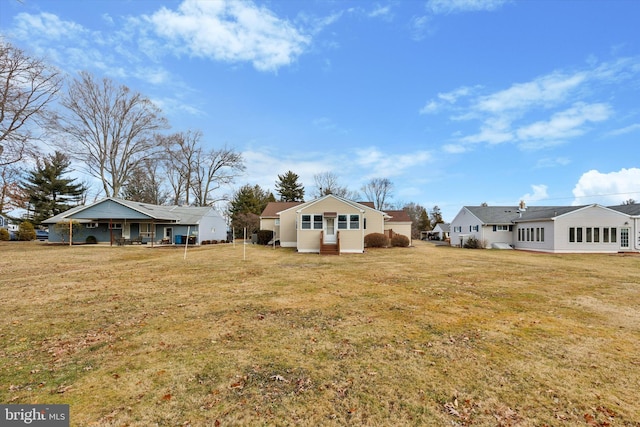 rear view of property with a yard