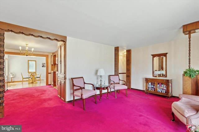 sitting room with a chandelier and carpet flooring