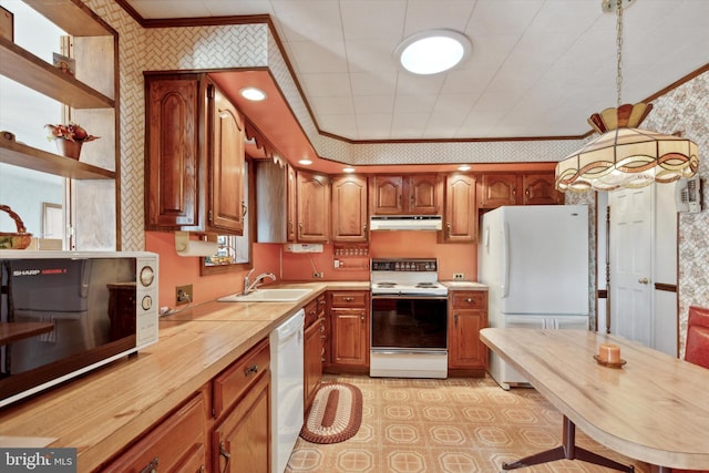 kitchen featuring crown molding, a sink, white appliances, under cabinet range hood, and wallpapered walls