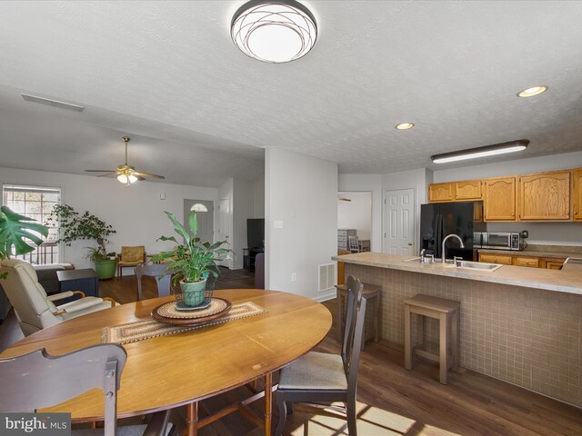 dining room featuring a textured ceiling, visible vents, wood finished floors, and recessed lighting