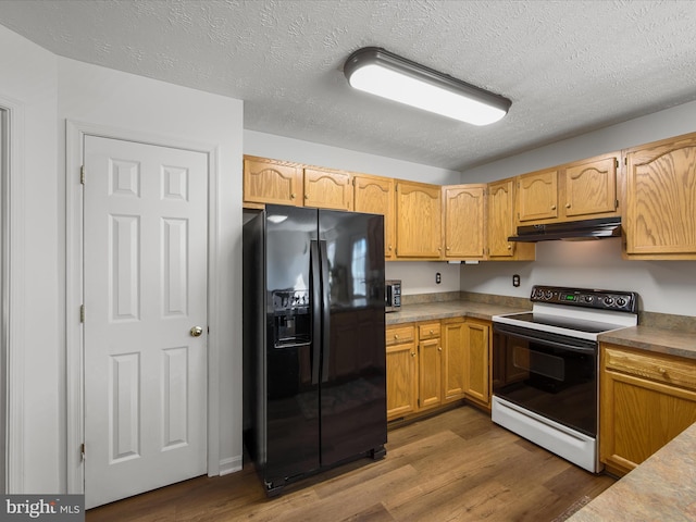 kitchen featuring dark wood-style flooring, black refrigerator with ice dispenser, under cabinet range hood, and range with electric stovetop