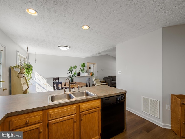 kitchen with visible vents, dark wood-type flooring, a sink, a textured ceiling, and dishwasher