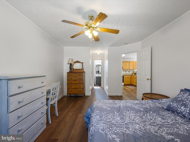 bedroom featuring dark wood-style floors, ceiling fan, ensuite bath, and baseboards