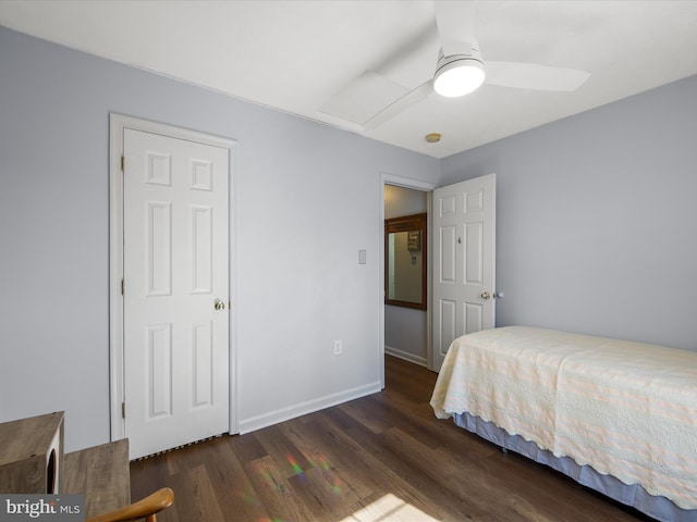 bedroom featuring dark wood-style floors, attic access, baseboards, and a ceiling fan