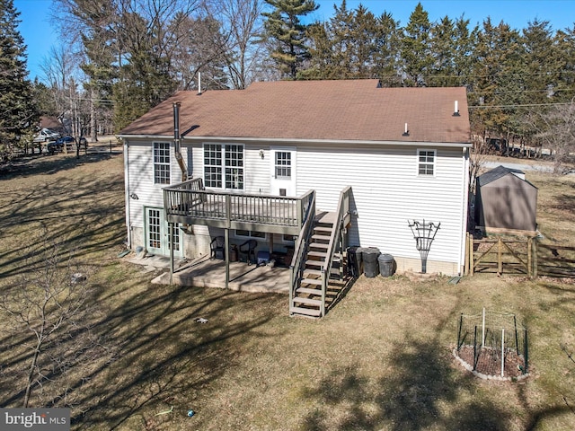 rear view of property featuring a wooden deck, a patio, stairs, fence, and a yard